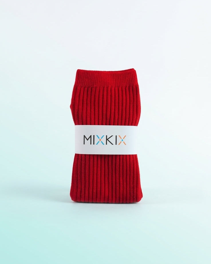A pair of folded red ribbed knit socks wrapped in a white paper band printed with the brand name 'MIXKIX', set against a clean white to light mint gradient background.