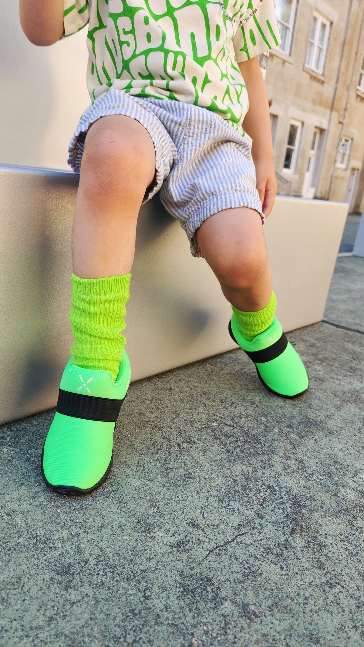 Active child wearing colourful MixKix sneakers and matching cotton socks on a playground.