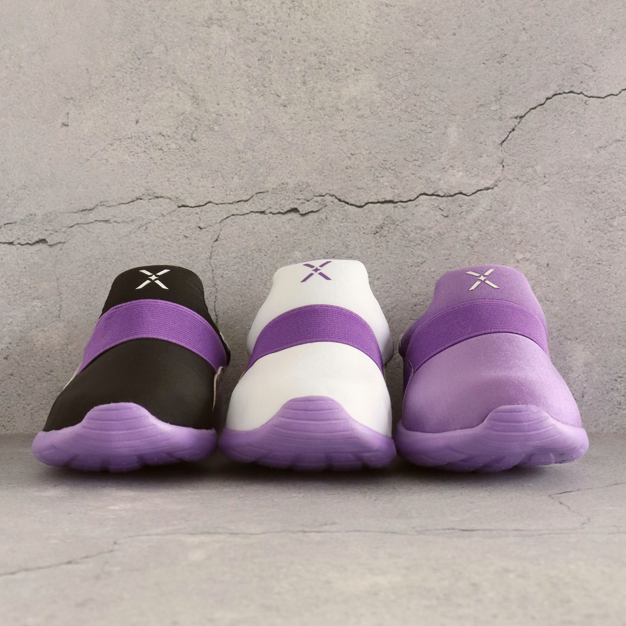 Three pairs of 90s Mix Collection kids sneakers in purple, white and black colours