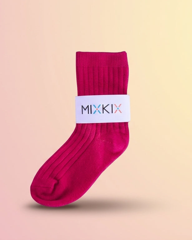 A magenta pink sock with a white elastic band featuring the brand name 'MIXKIX'. Crew sock in soft cotton for children. 