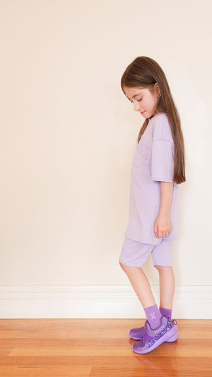 Girl wearing purple Mix Kix kids slip-on shoes and socks. 